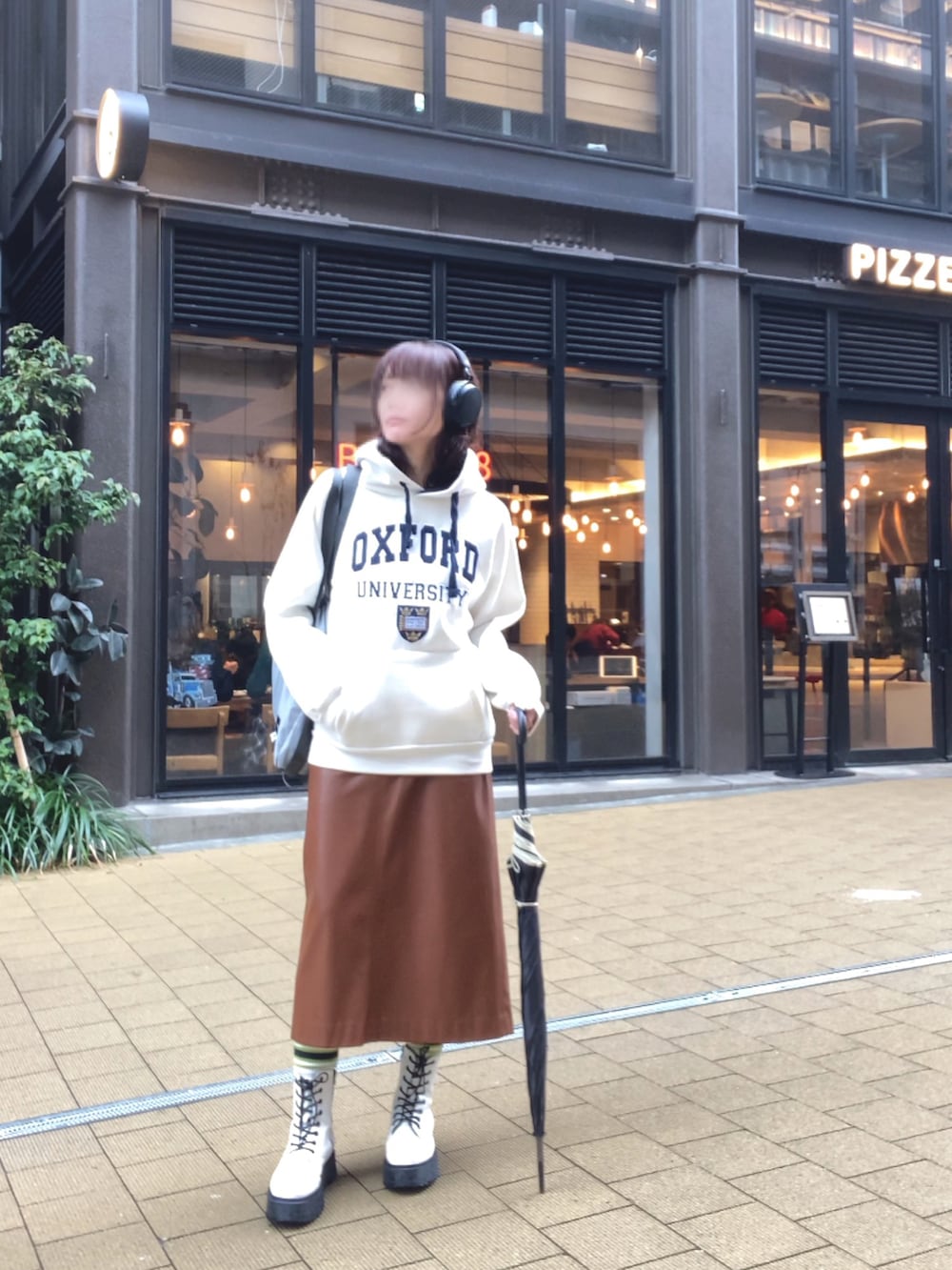 ホワイト系のパーカー、ブラウン系のスカート、ホワイト系のブーツを着用したレディースの秋コーディネートの3枚目の写真