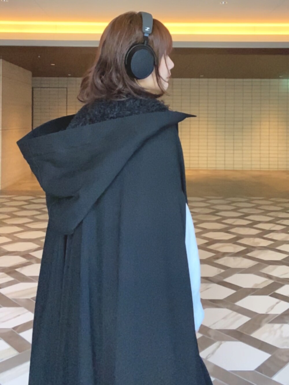 ブラック系のジャケット/アウター、ホワイト系のニット/セーター、ホワイト系のスカートを着用したレディースの冬コーディネートの4枚目の写真