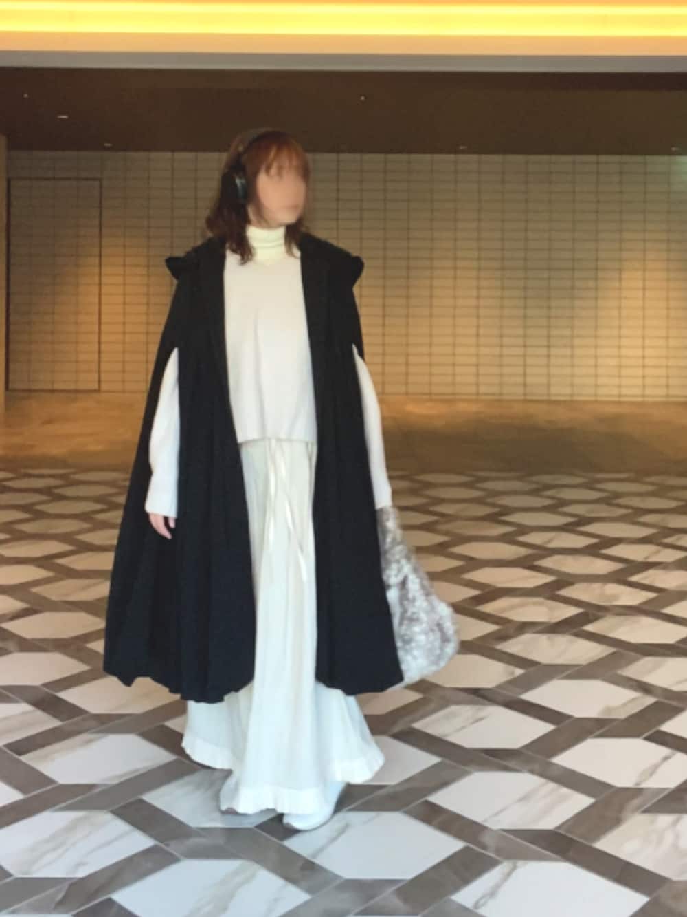 ブラック系のジャケット/アウター、ホワイト系のニット/セーター、ホワイト系のスカートを着用したレディースの冬コーディネートの2枚目の写真