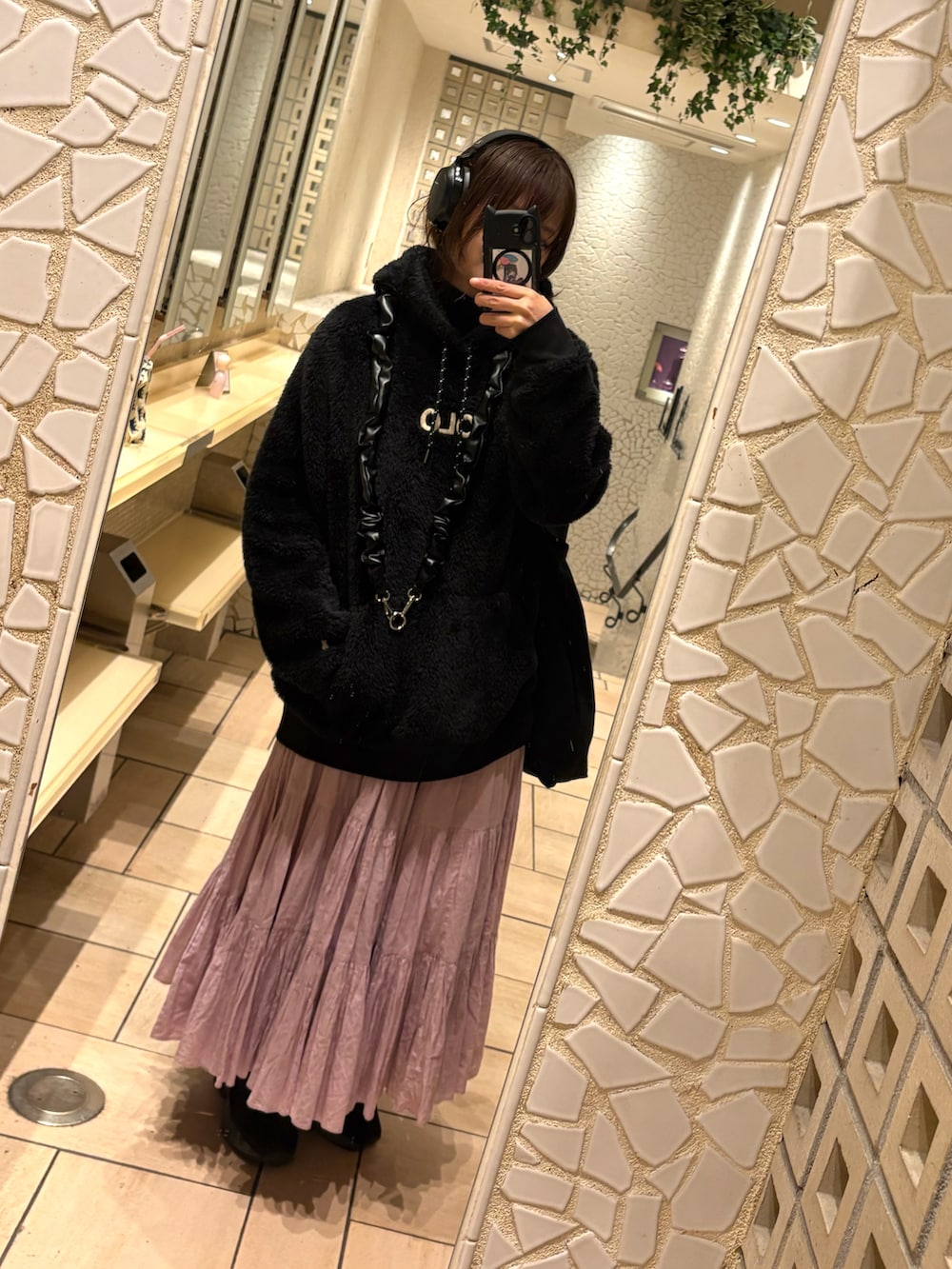 ピンク系のスカート、ブラック系のスニーカー、ブラック系のトップスを着用したレディースの秋コーディネートの2枚目の写真