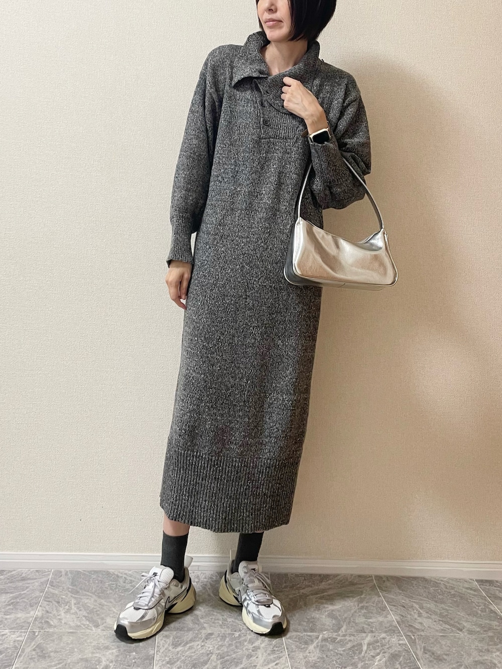 グレー系のワンピース、シルバー系のスニーカー、ベージュ系のデジタル腕時計を着用したレディースの秋コーディネートの2枚目の写真