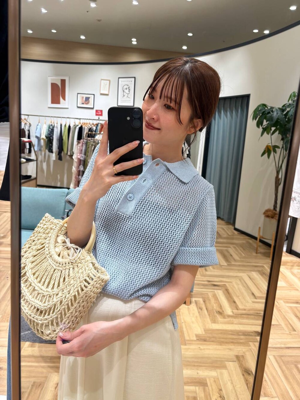 ブルー系のポロシャツ、ベージュ系のかごバッグ、ブラック系のサンダルを着用したレディースの夏コーディネートの5枚目の写真