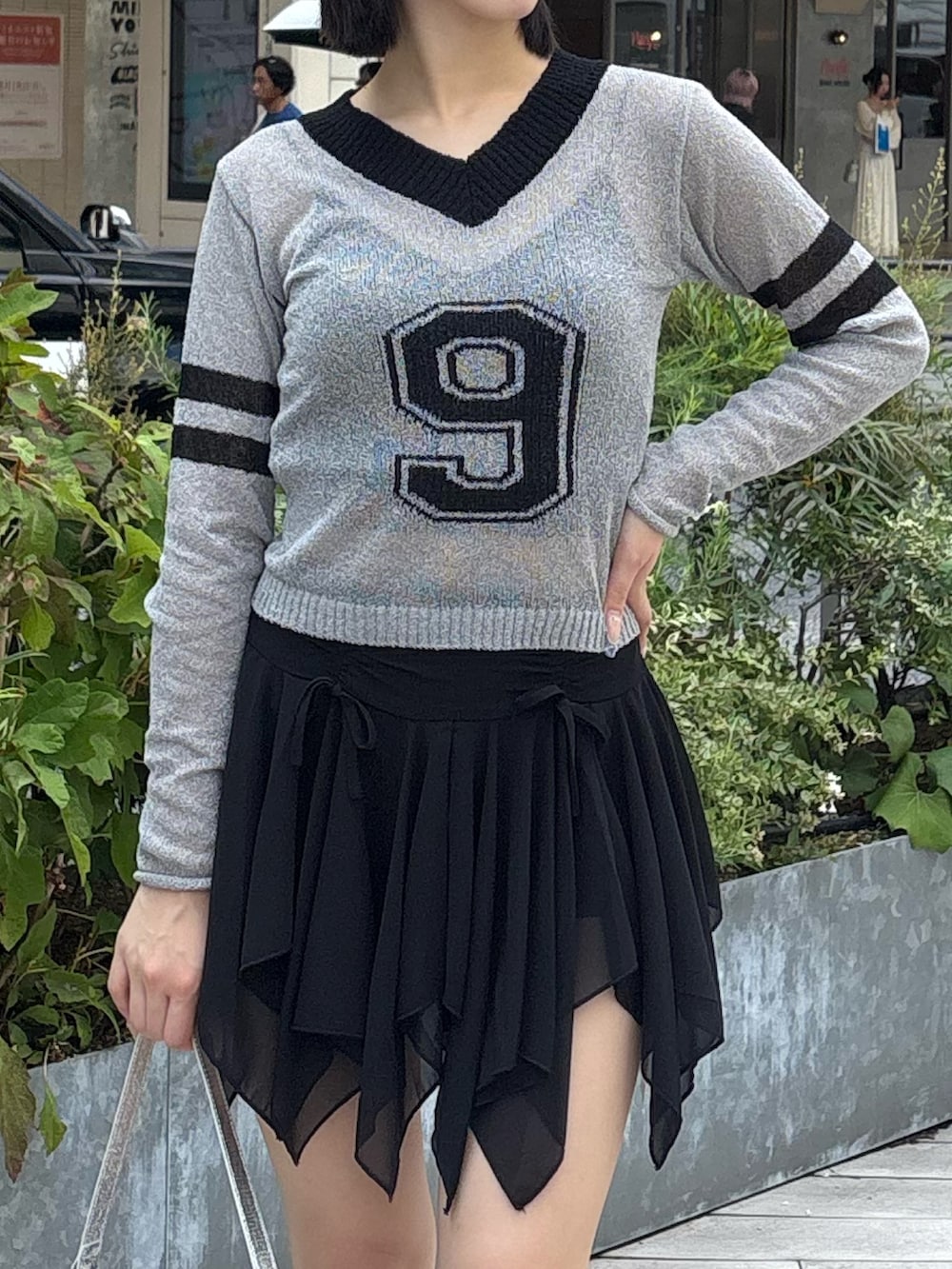 ブラック系のスカート、グレー系のニット/セーター、ブラック系のキャミソールを着用したレディースの夏コーディネートの2枚目の写真