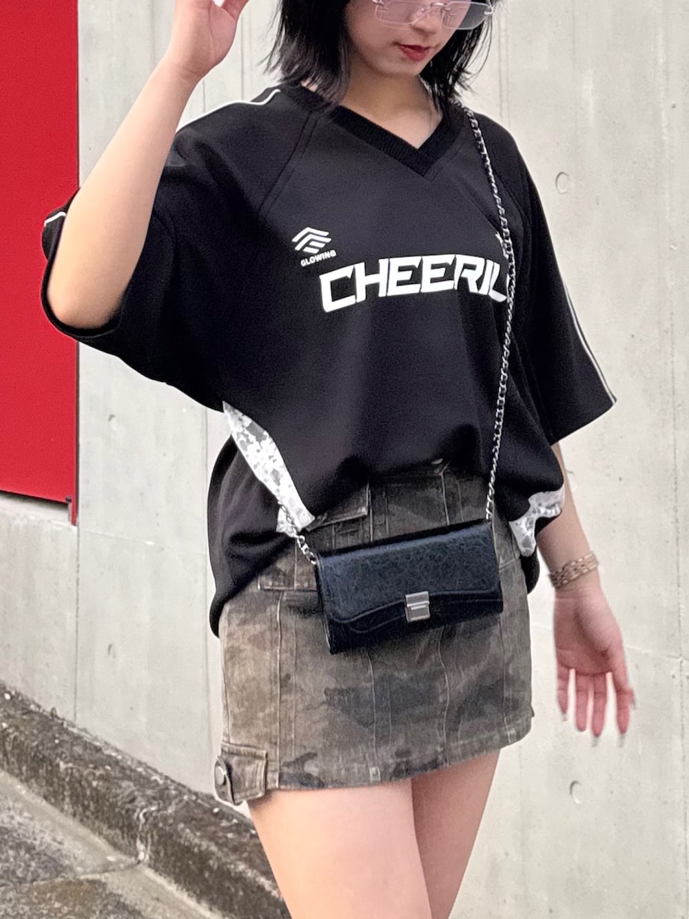 ブラック系のTシャツ/カットソー、グリーン系のスカートを着用したレディースの春コーディネートの2枚目の写真