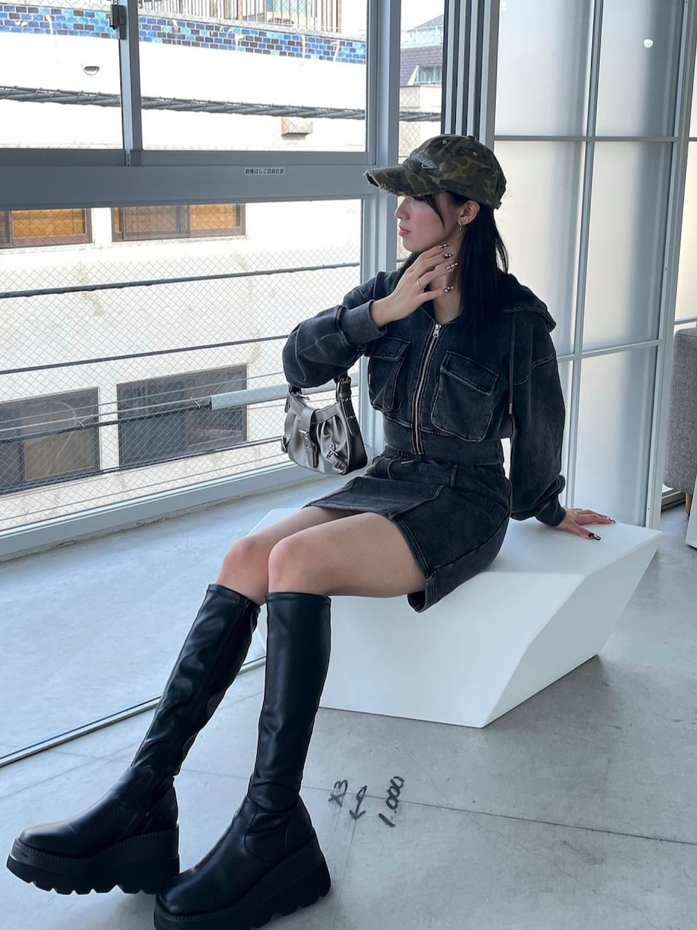 ブラック系のスカート、ブラック系のブーツ、ブラック系のスウェットを着用したレディースの秋コーディネートの2枚目の写真