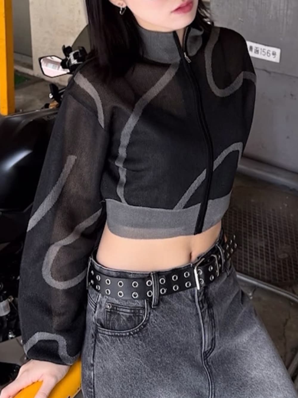 ブラック系のデニムパンツ、ブラック系のブルゾン、ブラック系のキャミソールを着用したレディースの夏コーディネートの2枚目の写真