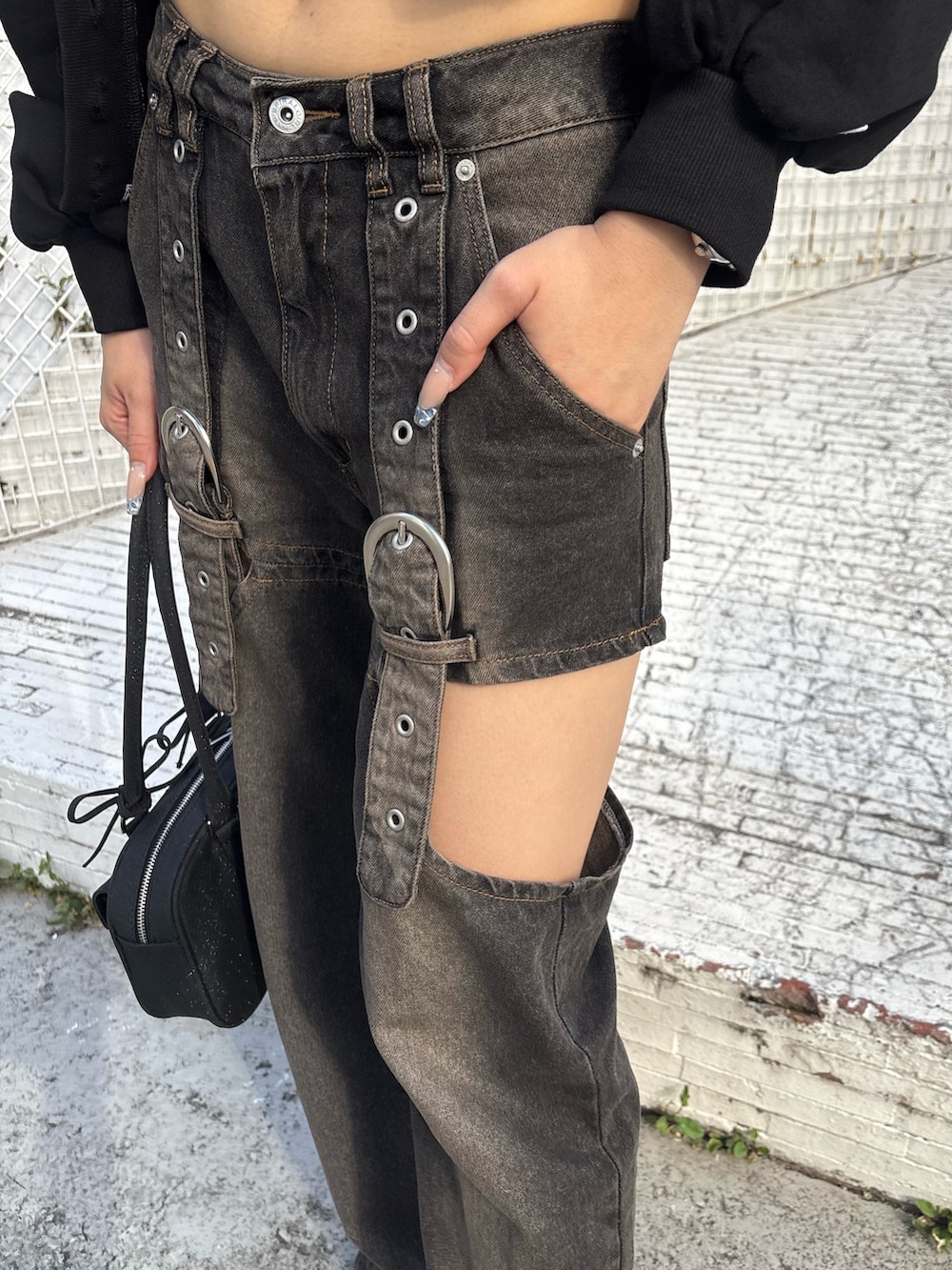 ブラック系のデニムパンツ、ブラック系のハンドバッグ、ブルー系のチューブトップを着用したレディースの夏コーディネートの3枚目の写真