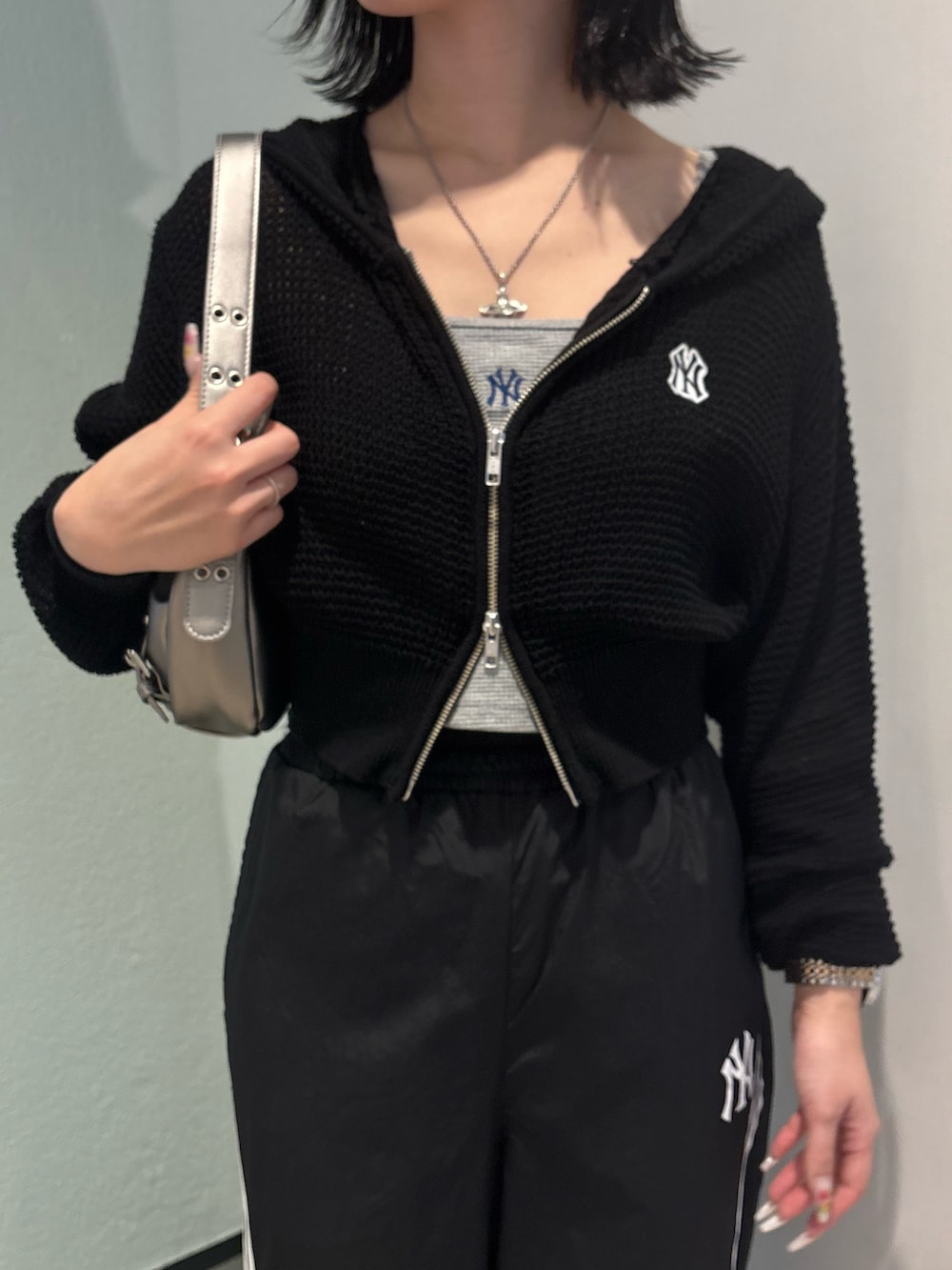 ブラック系のその他パンツ、ブラック系のパーカー、グレー系のキャミソールを着用したレディースの春コーディネートの2枚目の写真