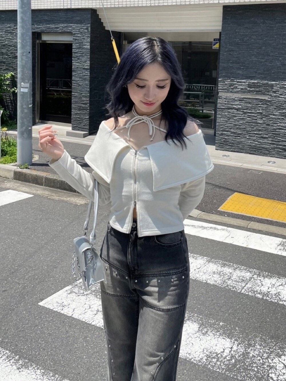 シルバー系のブーツ、ブラック系のデニムパンツ、ホワイト系のスウェットを着用したレディースの秋コーディネートの2枚目の写真