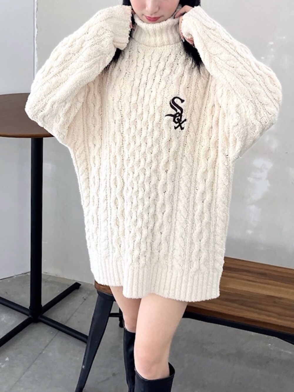 ブルー系のデニムパンツ、ブラック系のブーツ、ホワイト系のニット/セーターを着用したレディースの冬コーディネートの2枚目の写真