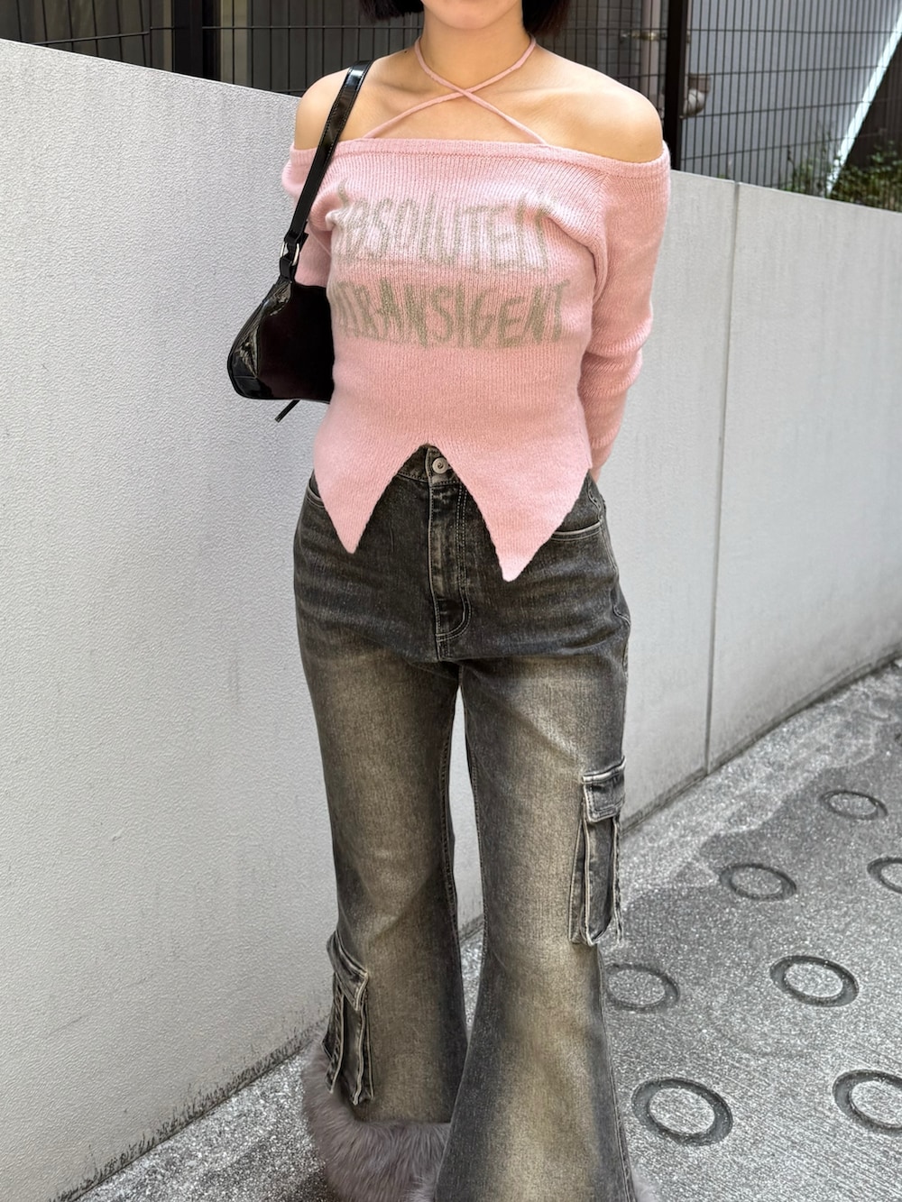 ピンク系のニット/セーター、ブラック系のデニムパンツ、ブラック系のパンプスを着用したレディースの秋コーディネートの2枚目の写真