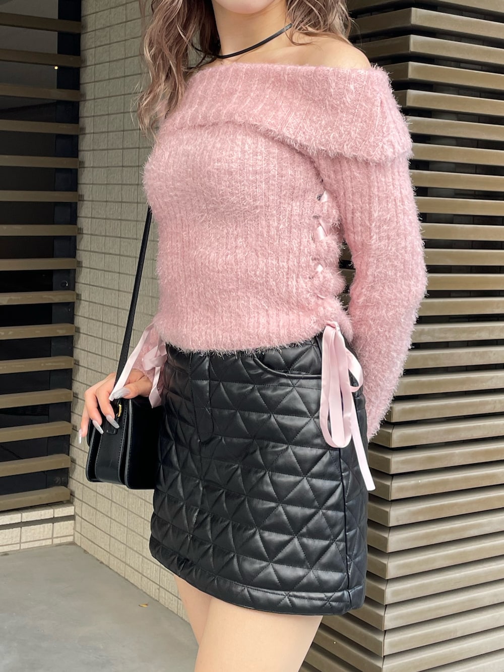 ピンク系のニット/セーター、ブラック系のスカートを着用したレディースの秋コーディネートの3枚目の写真