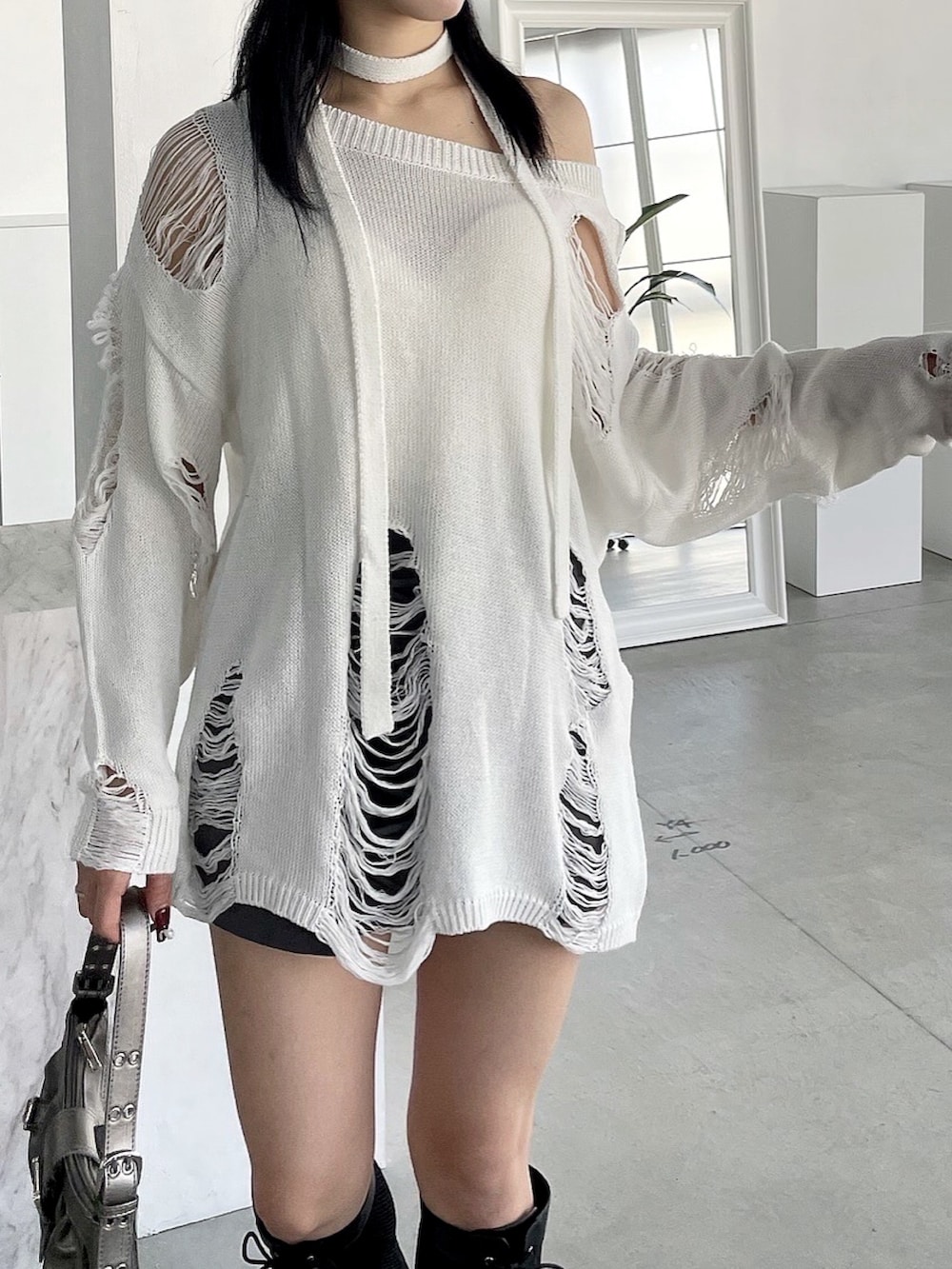 ホワイト系のチューブトップ、ホワイト系のニット/セーター、グレー系のスカートを着用したレディースの冬コーディネートの2枚目の写真