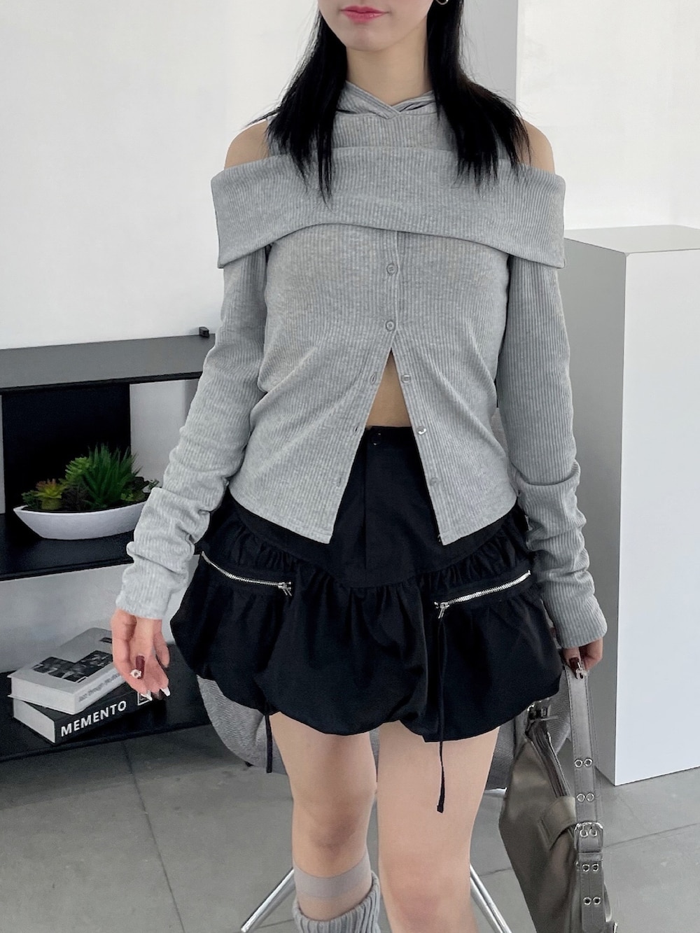 ブラック系のスカート、グレー系のTシャツ/カットソー、ブラック系のパンプスを着用したレディースの冬コーディネートの2枚目の写真