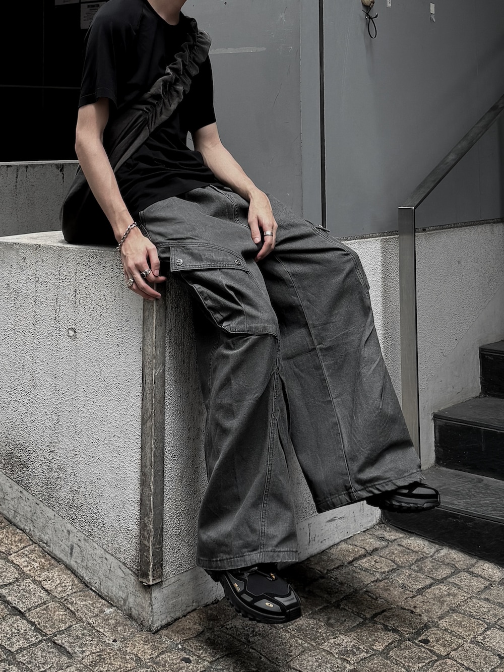 ブラック系のTシャツ/カットソー、ブラック系のスニーカー、ブラック系のデニムパンツを着用したメンズの夏コーディネートの2枚目の写真