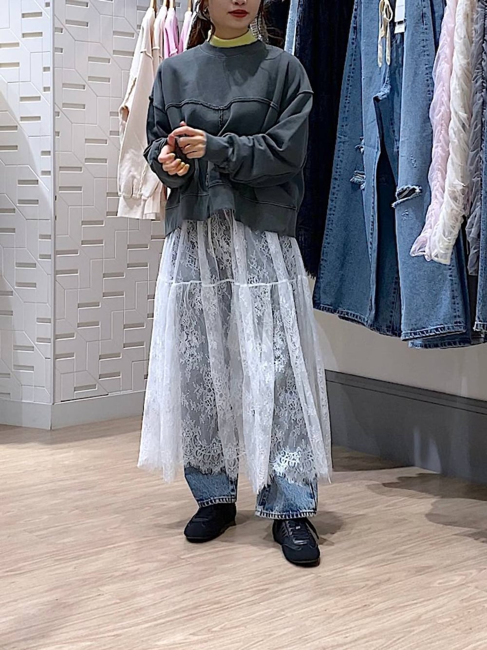 イエロー系のニット/セーター、ブルー系のデニムパンツ、ブラック系のスウェットを着用したレディースの冬コーディネートの3枚目の写真