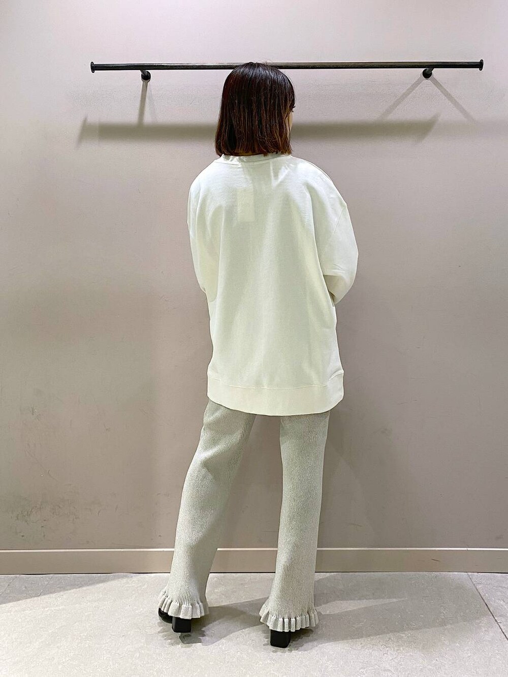 ホワイト系のスウェット、シルバー系のその他パンツ、ブラック系のパンプスを着用したレディースの秋コーディネートの3枚目の写真