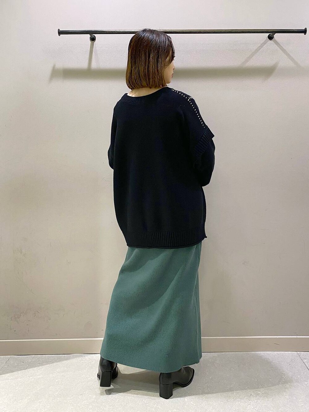 ブラック系のTシャツ/カットソー、グリーン系のワンピース、ブラック系のパンプスを着用したレディースの秋コーディネートの3枚目の写真