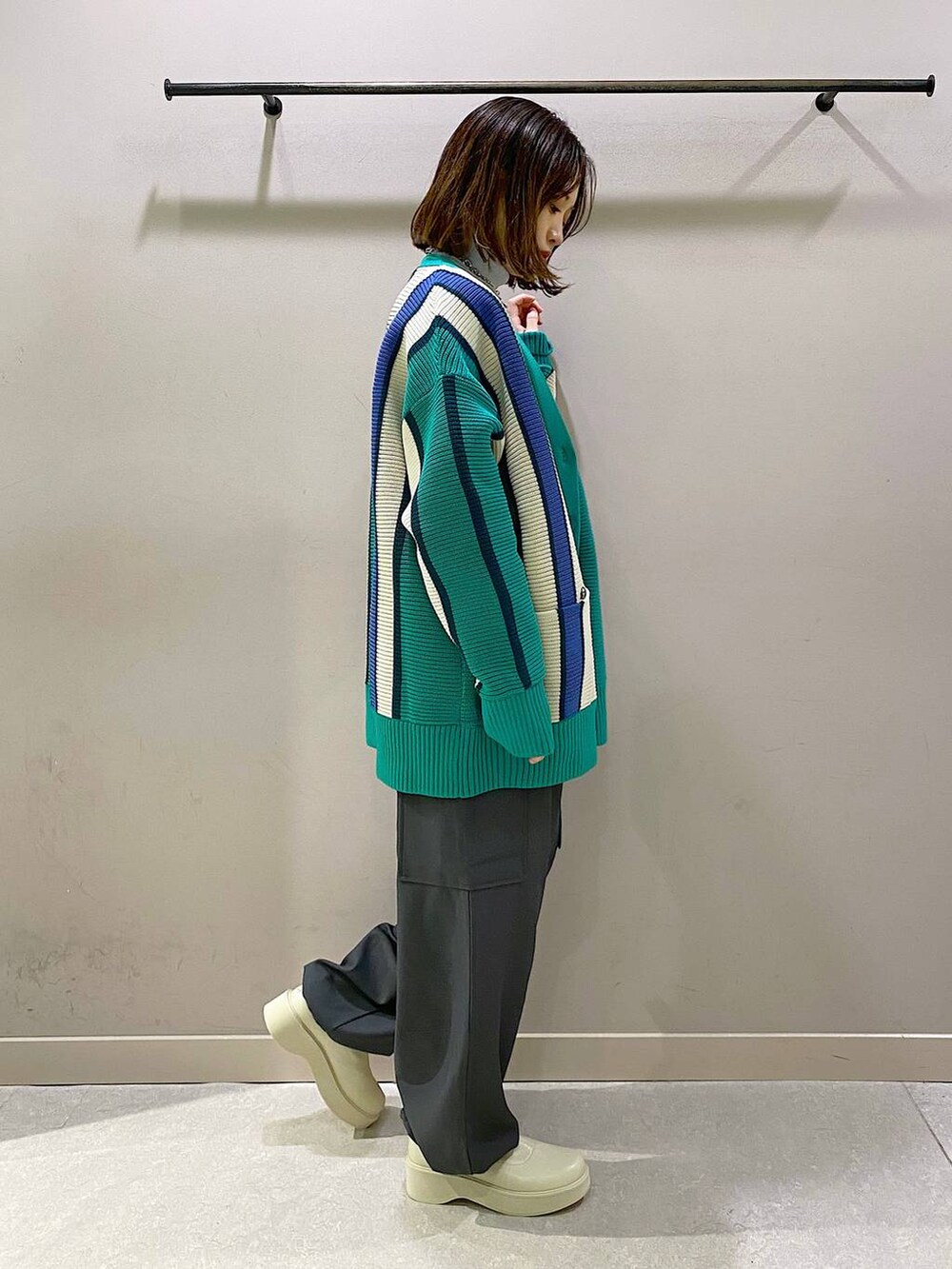 グリーン系のニット/セーター、ホワイト系のブーツ、シルバー系のTシャツ/カットソーを着用したレディースの秋コーディネートの4枚目の写真