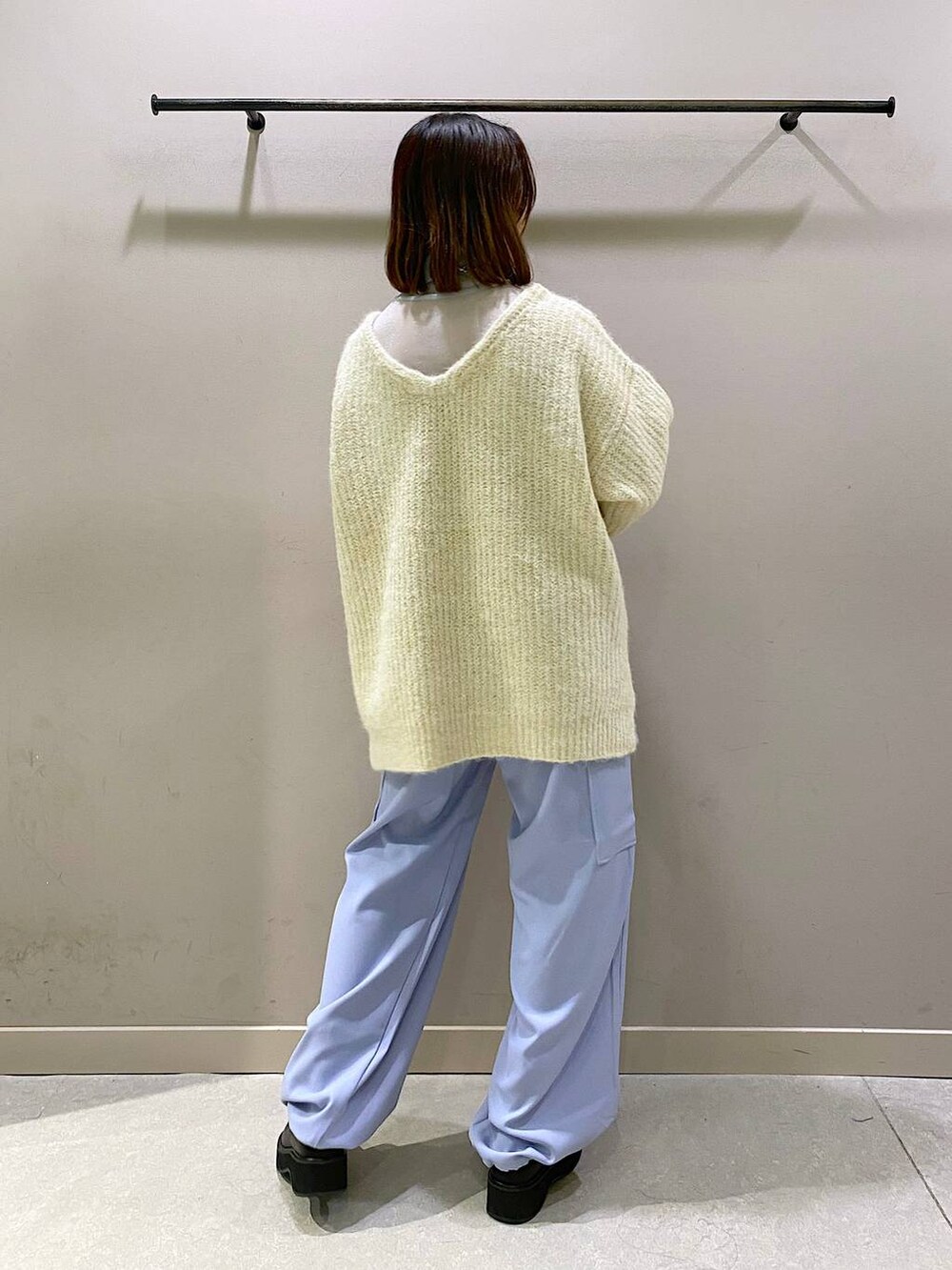 ホワイト系のニット/セーター、ブラック系のブーツ、シルバー系のTシャツ/カットソーを着用したレディースの秋コーディネートの3枚目の写真