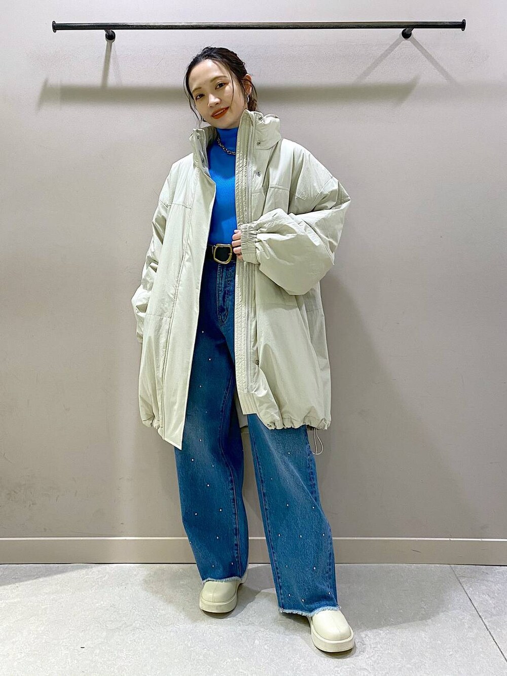 ホワイト系のダウンジャケット/コート、ブルー系のニット/セーター、ホワイト系のブーツを着用したレディースの冬コーディネートの5枚目の写真