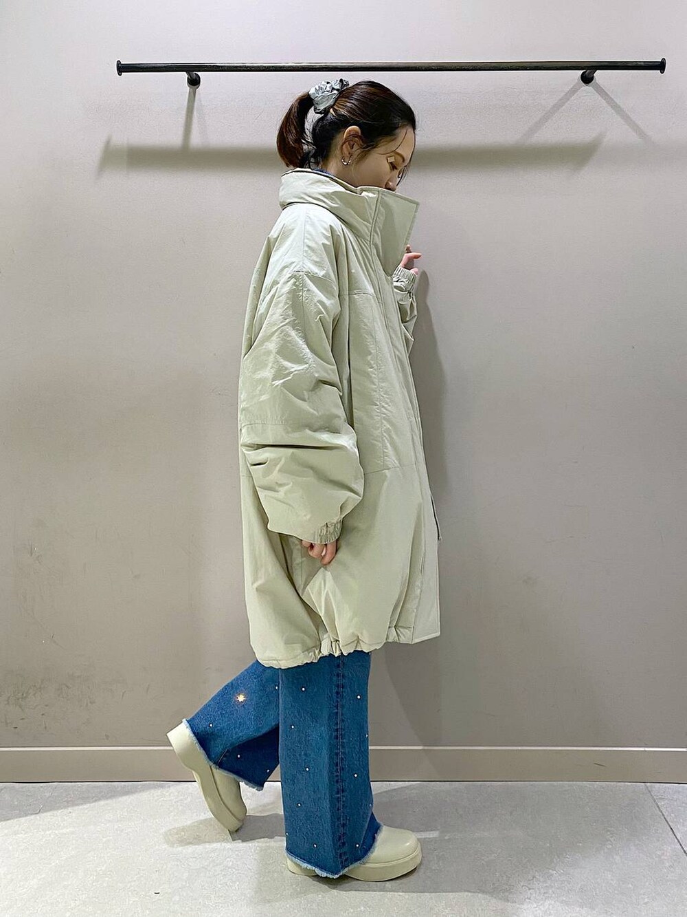 ホワイト系のダウンジャケット/コート、ブルー系のニット/セーター、ホワイト系のブーツを着用したレディースの冬コーディネートの2枚目の写真