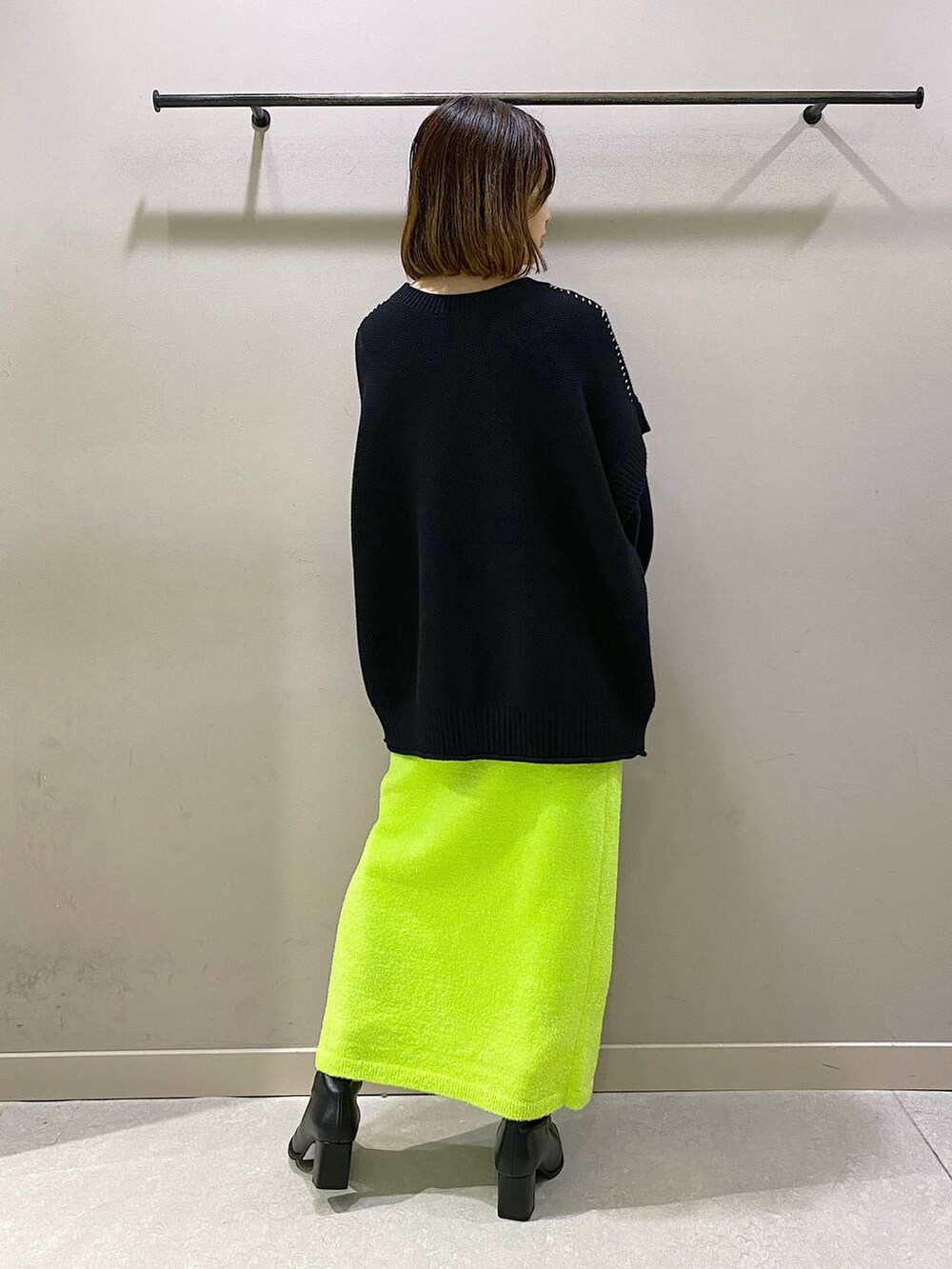 ブラック系のTシャツ/カットソー、ブラック系のパンプス、グリーン系のスカートを着用したレディースの秋コーディネートの3枚目の写真