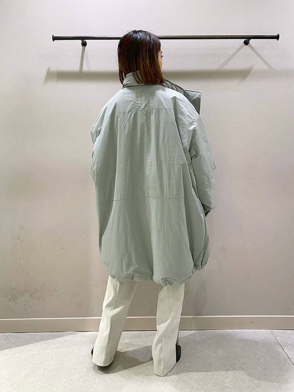 グリーン系のダウンジャケット/コート、グリーン系のTシャツ/カットソー、ブラック系のパンプスを着用したレディースの秋コーディネートの3枚目の写真