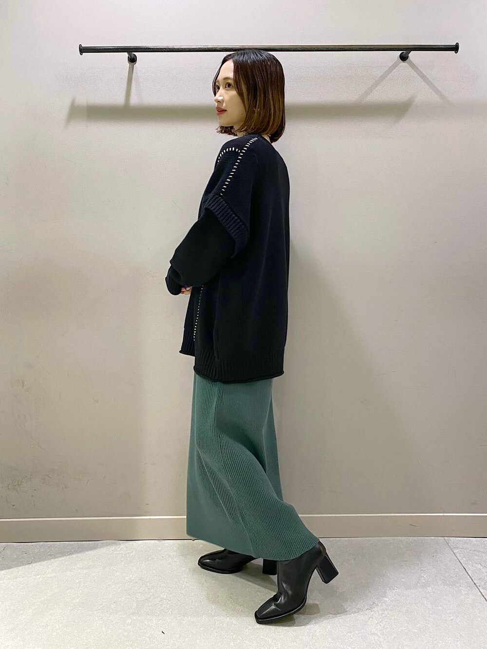 ブラック系のTシャツ/カットソー、グリーン系のワンピース、ブラック系のパンプスを着用したレディースの秋コーディネートの2枚目の写真