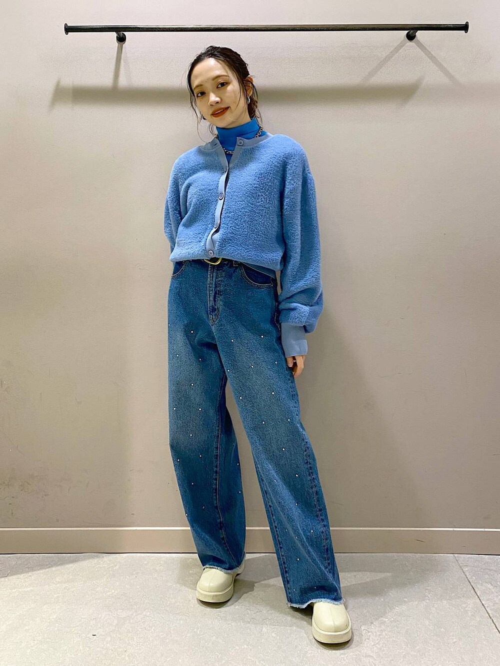 ブルー系のニット/セーター、ホワイト系のブーツ、ブルー系のワンピースを着用したレディースの冬コーディネートの5枚目の写真