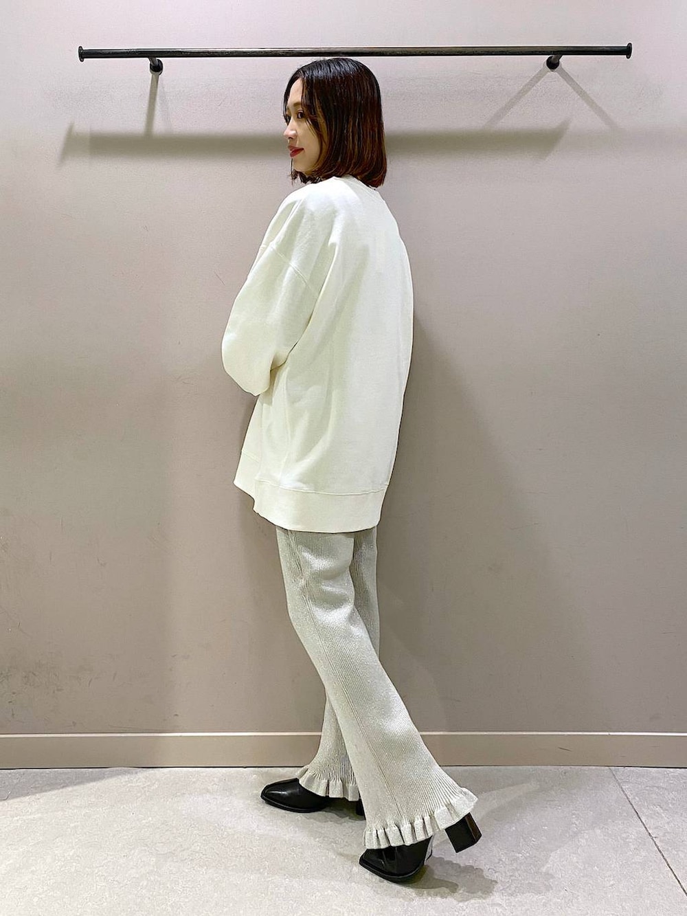 ホワイト系のスウェット、シルバー系のその他パンツ、ブラック系のパンプスを着用したレディースの秋コーディネートの2枚目の写真