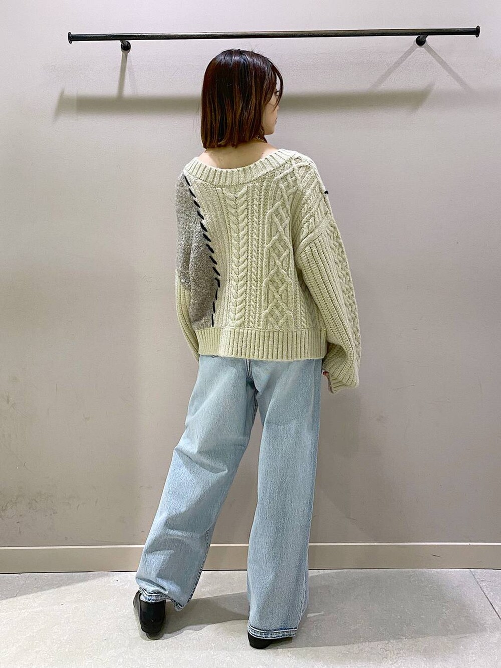 ホワイト系のキャミソール、ブルー系のデニムパンツ、ブラック系のパンプスを着用したレディースの秋コーディネートの3枚目の写真