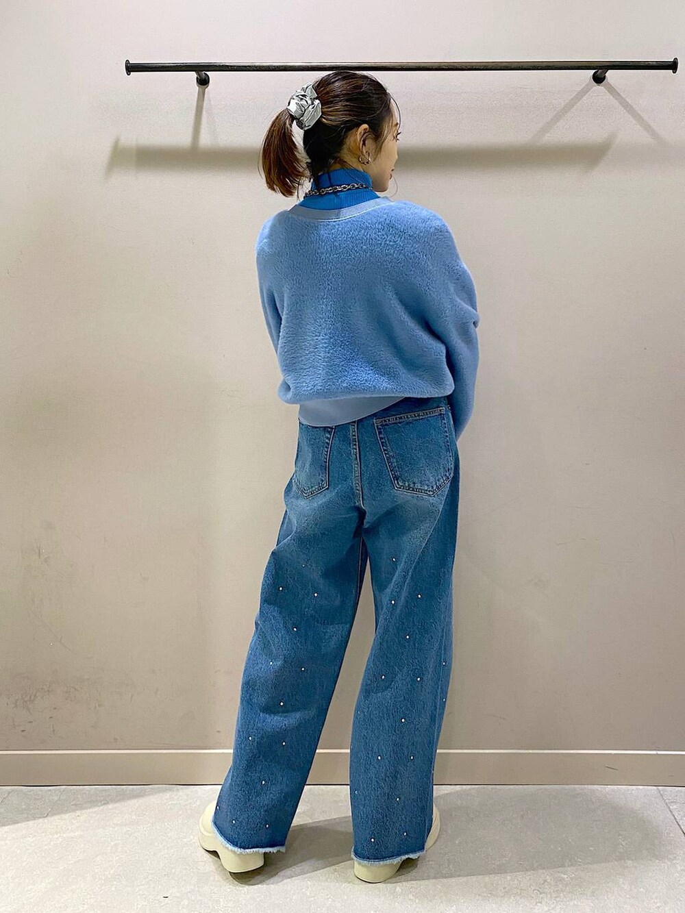 ブルー系のニット/セーター、ホワイト系のブーツ、ブルー系のワンピースを着用したレディースの冬コーディネートの3枚目の写真