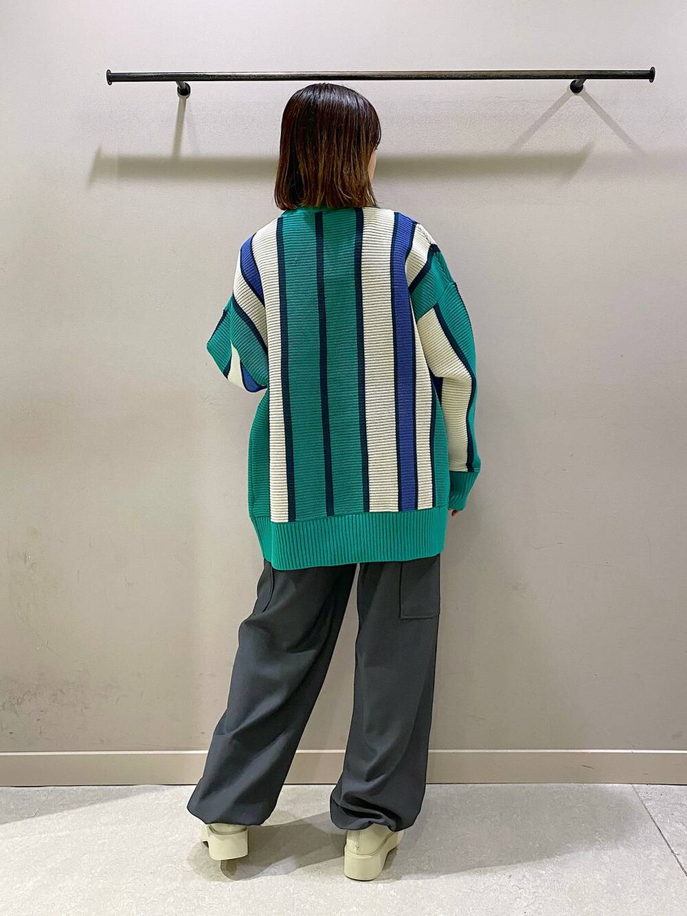 グリーン系のニット/セーター、ホワイト系のブーツ、シルバー系のTシャツ/カットソーを着用したレディースの秋コーディネートの3枚目の写真