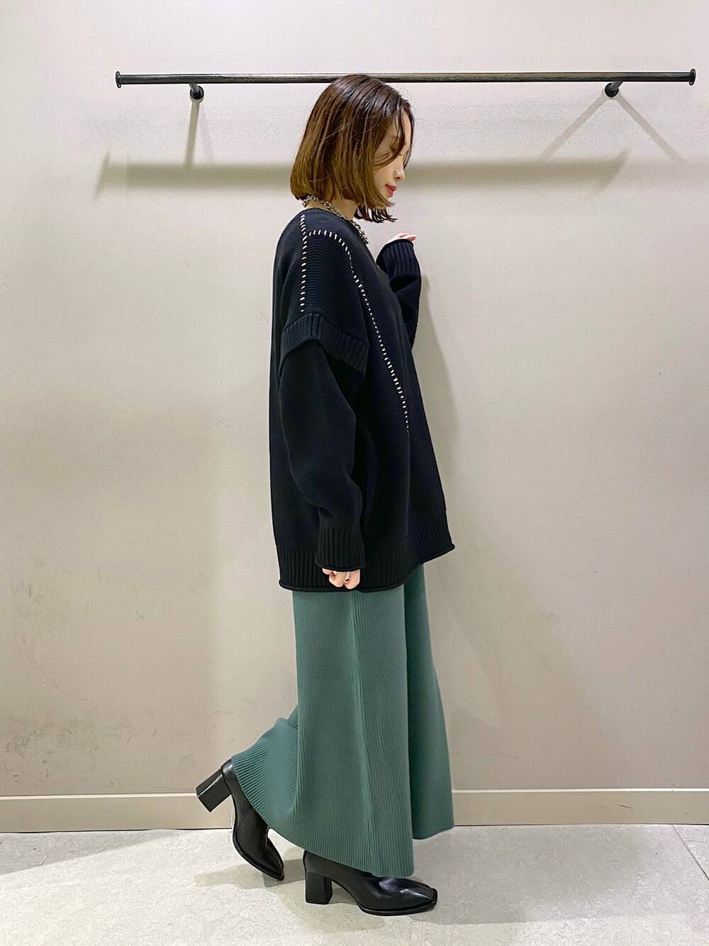 ブラック系のTシャツ/カットソー、グリーン系のワンピース、ブラック系のパンプスを着用したレディースの秋コーディネートの4枚目の写真