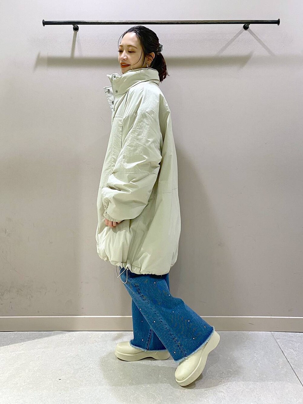 ホワイト系のダウンジャケット/コート、ブルー系のニット/セーター、ホワイト系のブーツを着用したレディースの冬コーディネートの4枚目の写真