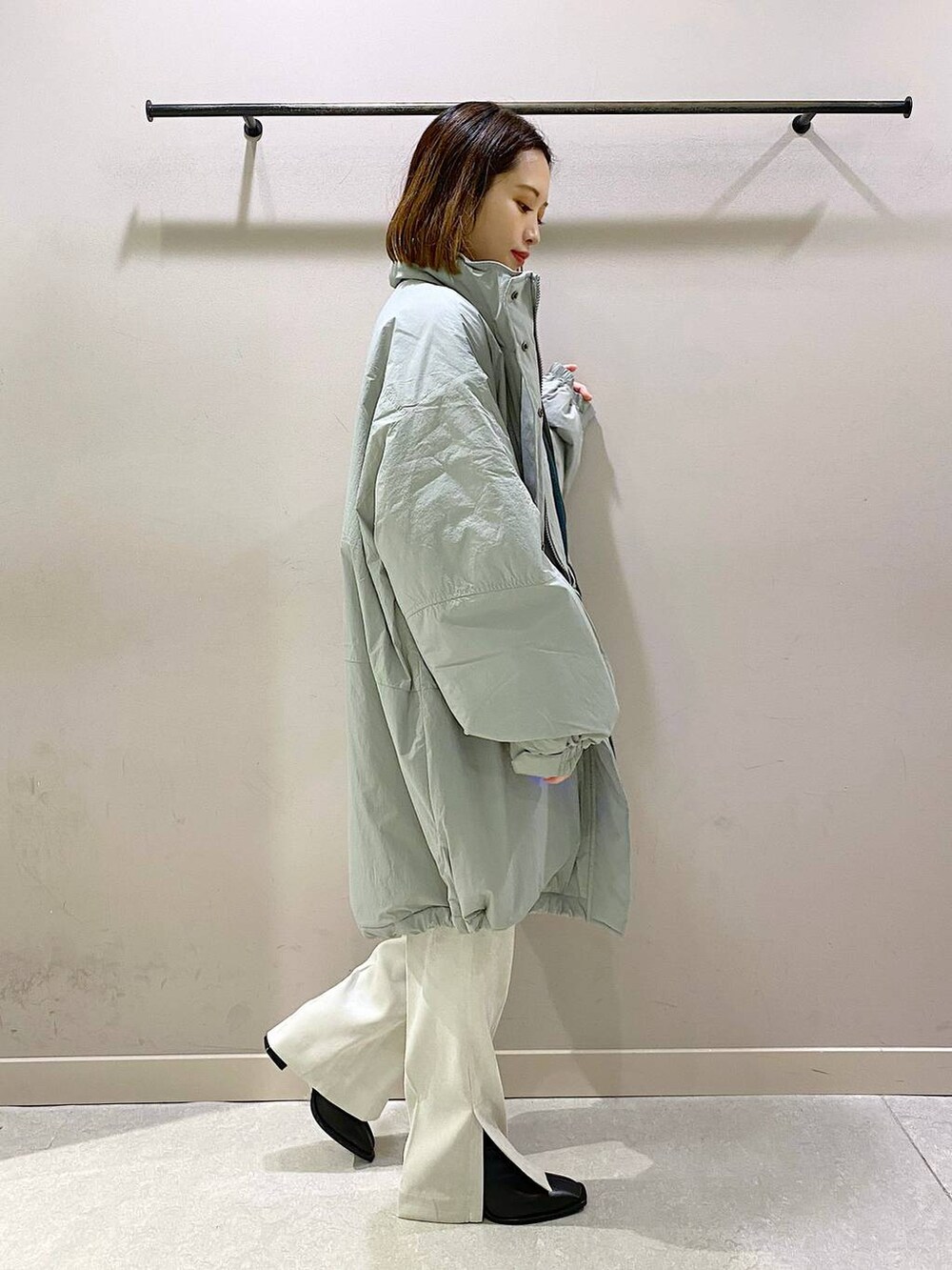 グリーン系のダウンジャケット/コート、グリーン系のTシャツ/カットソー、ブラック系のパンプスを着用したレディースの秋コーディネートの2枚目の写真