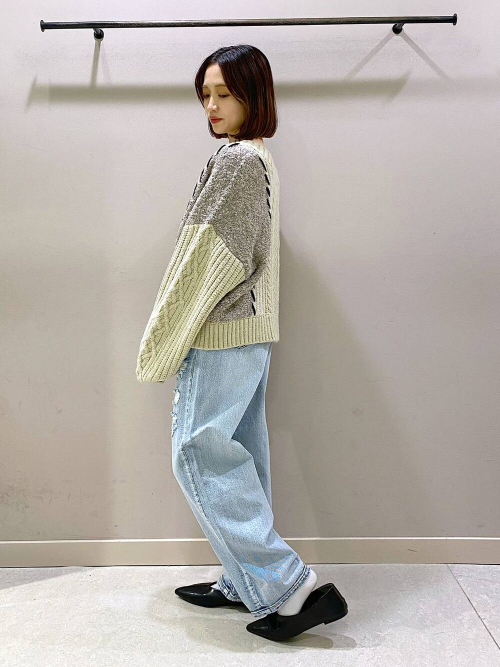 ホワイト系のキャミソール、ブルー系のデニムパンツ、ブラック系のパンプスを着用したレディースの秋コーディネートの4枚目の写真