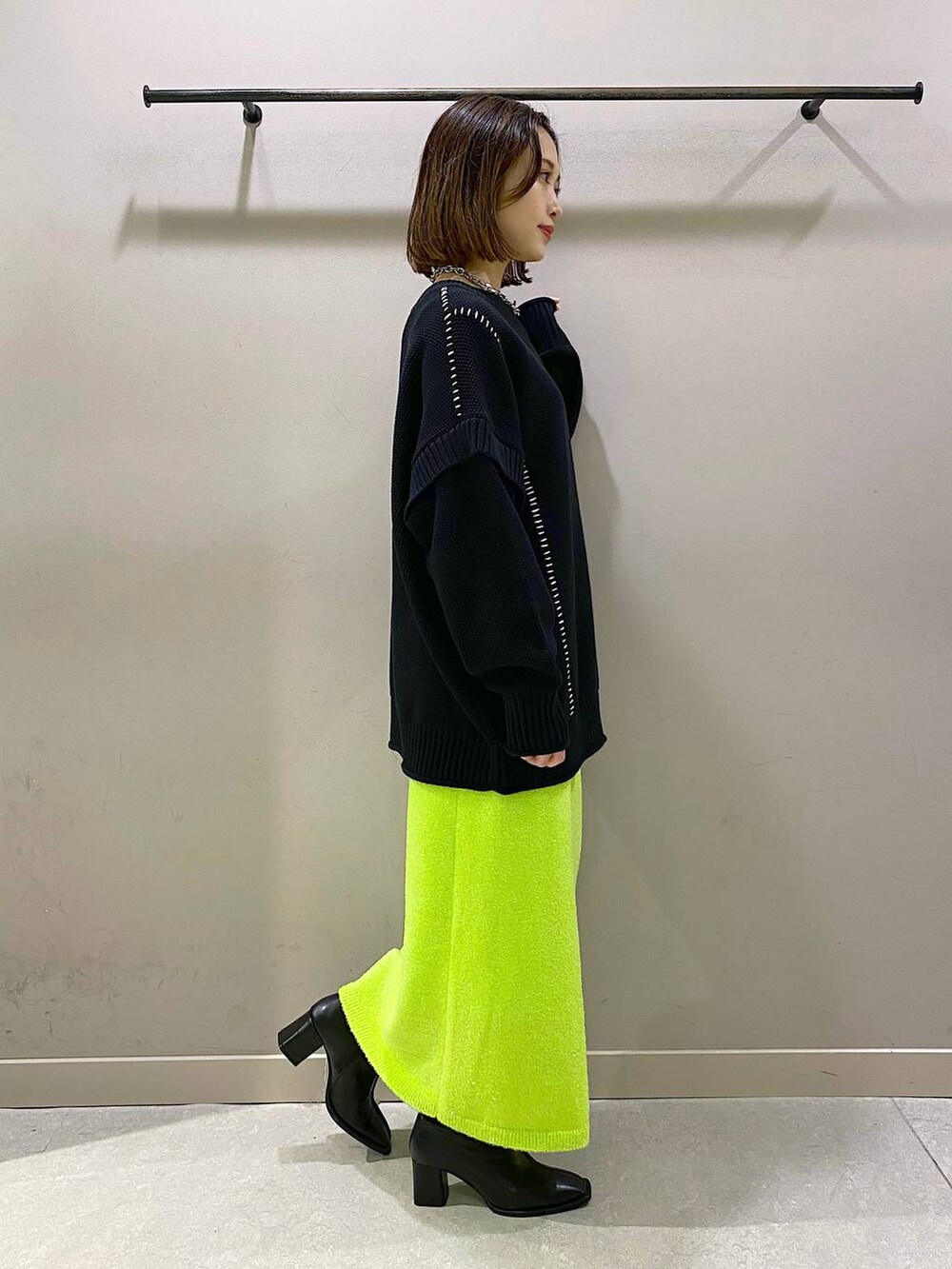 ブラック系のTシャツ/カットソー、ブラック系のパンプス、グリーン系のスカートを着用したレディースの秋コーディネートの4枚目の写真