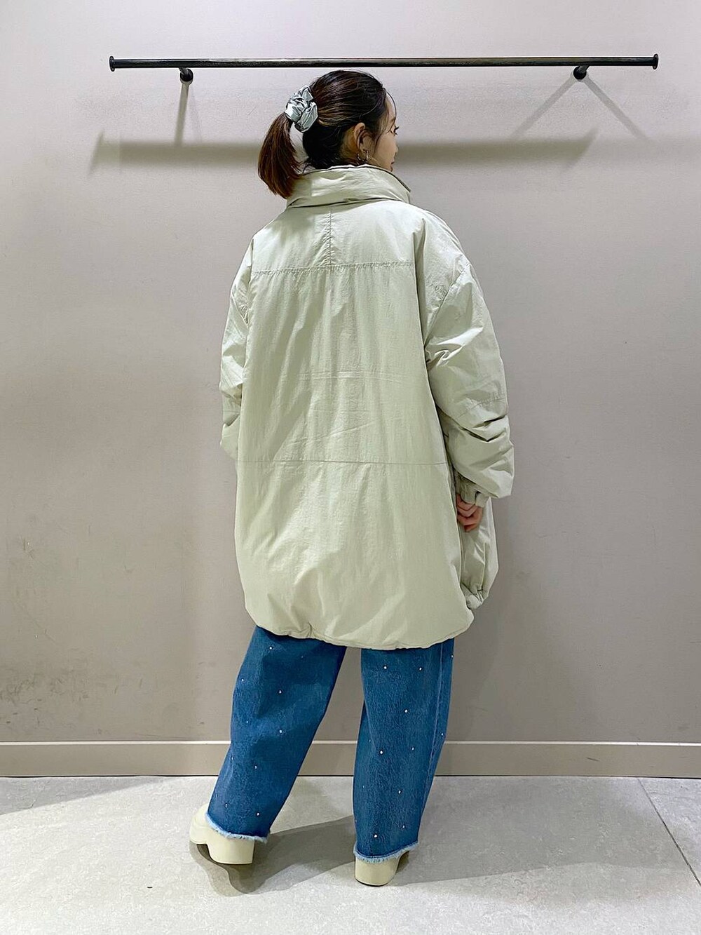 ホワイト系のダウンジャケット/コート、ブルー系のニット/セーター、ホワイト系のブーツを着用したレディースの冬コーディネートの3枚目の写真