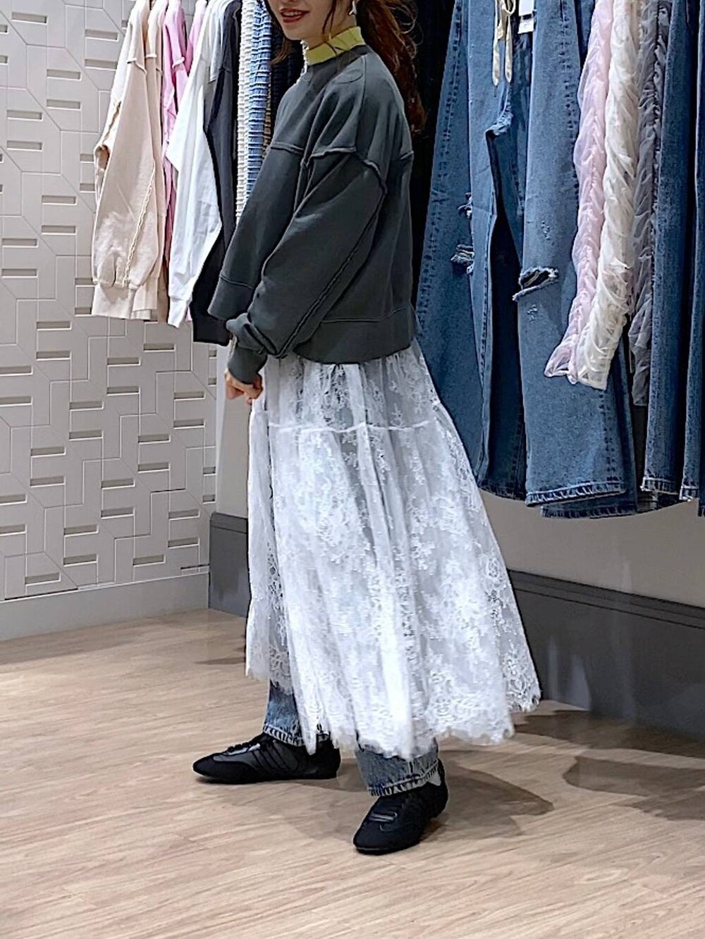 イエロー系のニット/セーター、ブルー系のデニムパンツ、ブラック系のスウェットを着用したレディースの冬コーディネートの2枚目の写真