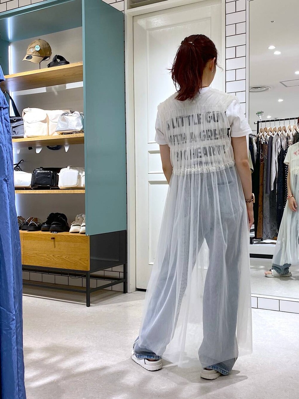 ホワイト系のサンダル、ホワイト系のワンピース、ホワイト系のTシャツ/カットソーを着用したレディースの秋コーディネートの3枚目の写真