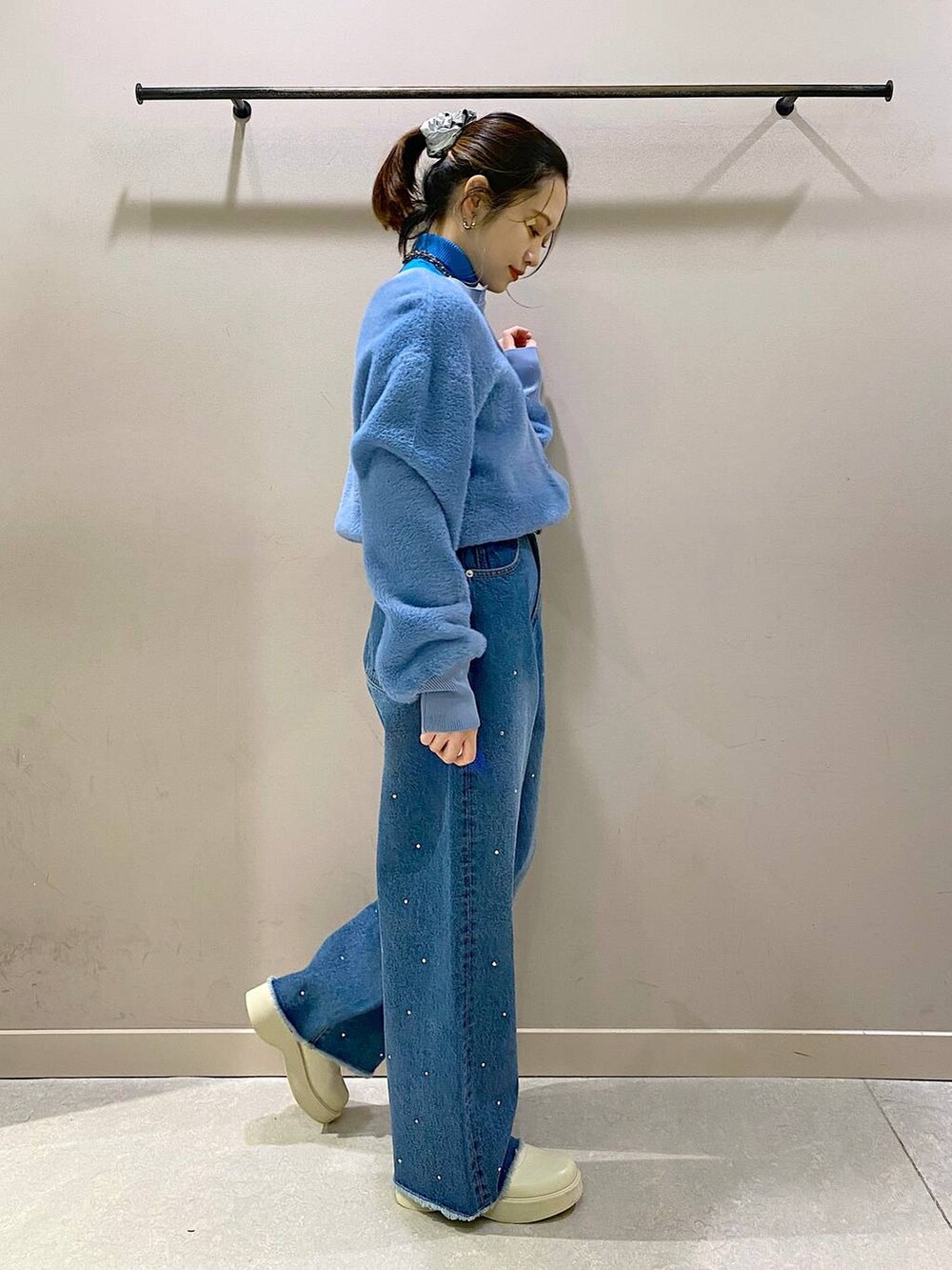 ブルー系のニット/セーター、ホワイト系のブーツ、ブルー系のワンピースを着用したレディースの冬コーディネートの4枚目の写真