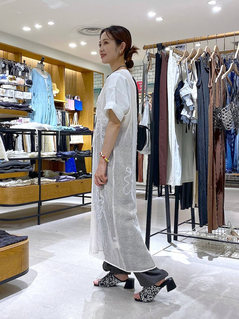 グレー系のカーゴパンツ、シルバー系のサンダル、ホワイト系のワンピースを着用したレディースの秋コーディネートの2枚目の写真