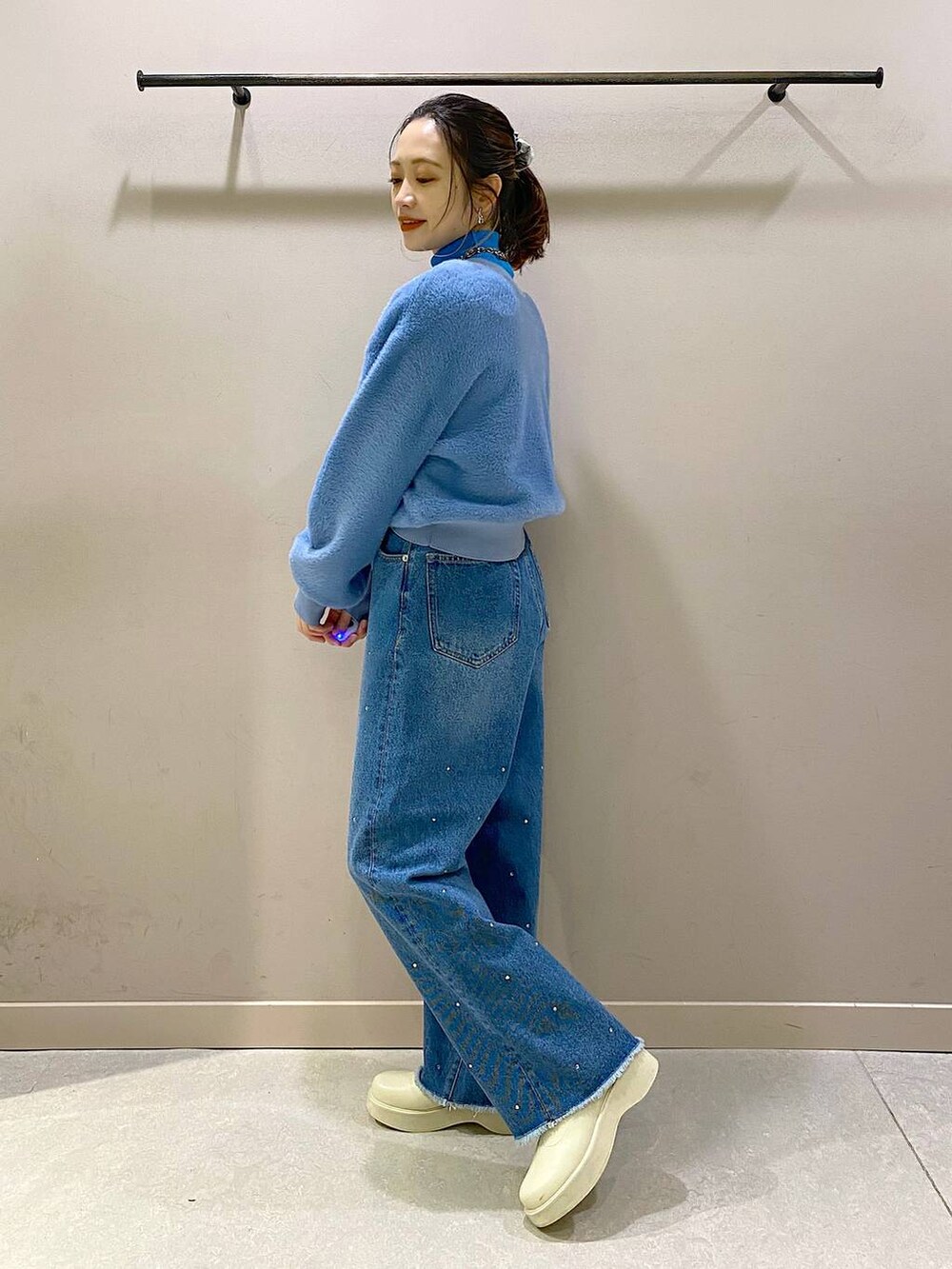 ブルー系のニット/セーター、ホワイト系のブーツ、ブルー系のワンピースを着用したレディースの冬コーディネートの2枚目の写真