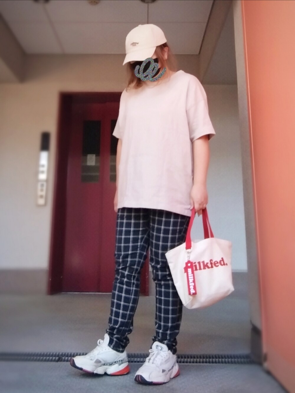 レッド系のマウンテンパーカー、ベージュ系のTシャツ/カットソー、ブラック系のその他パンツを着用したレディースの秋コーディネートの2枚目の写真