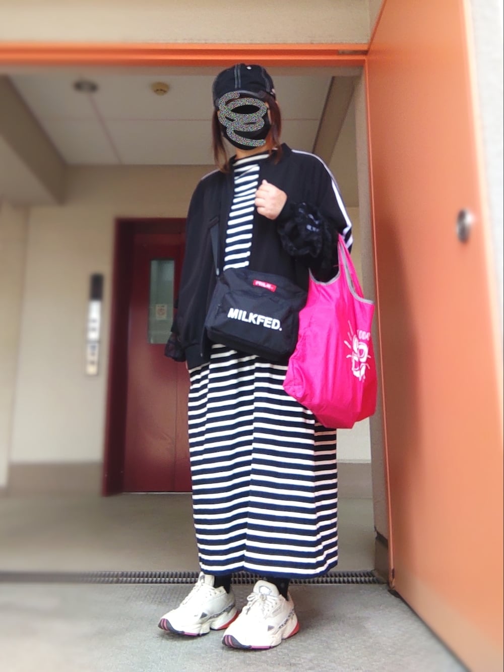 ブルー系のワンピース、ブラック系のバックパック/リュック、ホワイト系のスニーカーを着用したレディースの春コーディネートの2枚目の写真