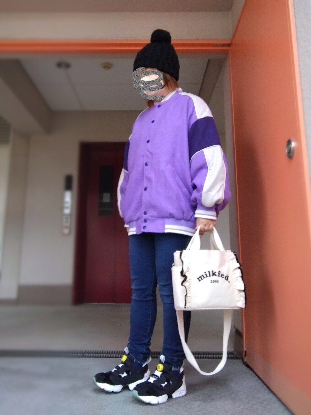 パープル系のスタジャン、ブラック系のTシャツ/カットソー、ブルー系のデニムパンツを着用したレディースの秋コーディネートの2枚目の写真