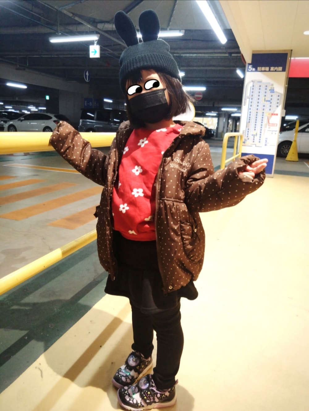 レッド系のスウェット、ブラウン系のダウンジャケット/コート、ブラック系のスカートを着用したレディースの冬コーディネートの2枚目の写真