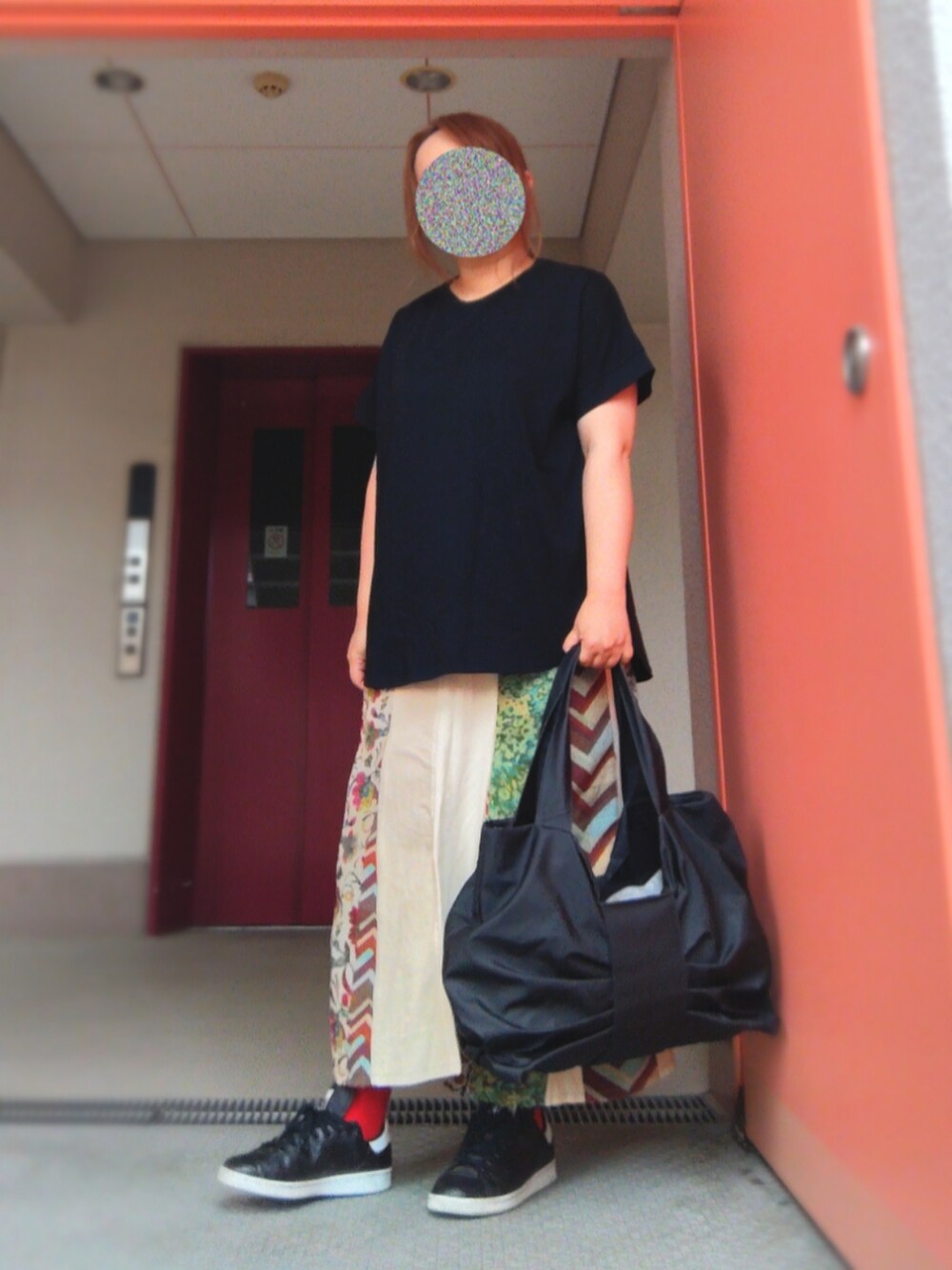 ブラック系のTシャツ/カットソー、ベージュ系のスカート、レッド系のトートバッグを着用したレディースの春コーディネートの2枚目の写真